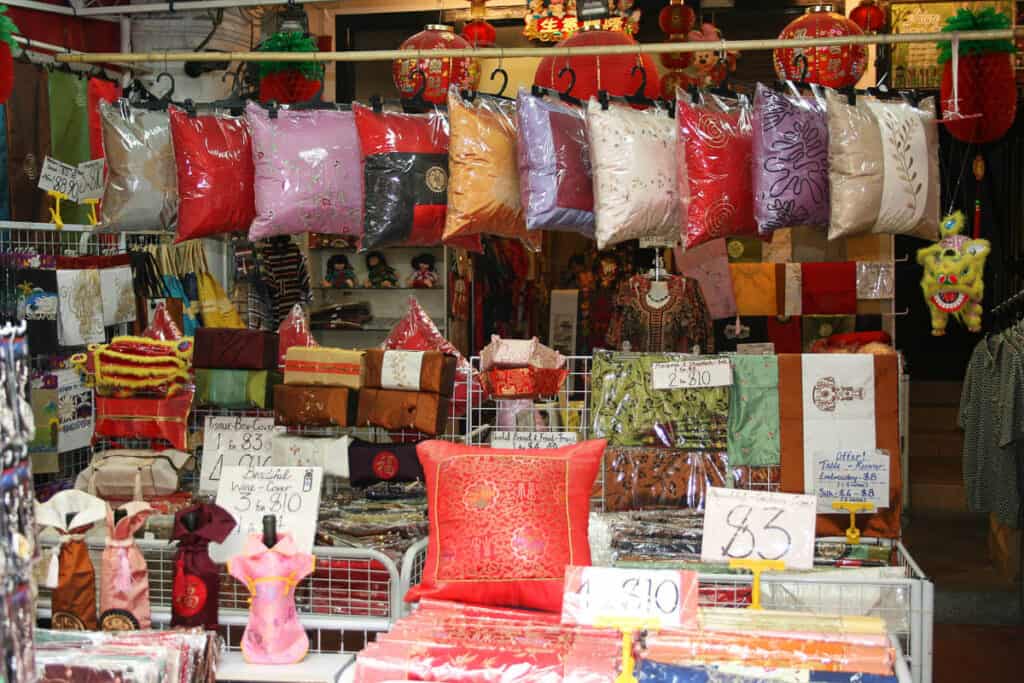Singapore Chinatown street market stall selling silk cushion covers.
