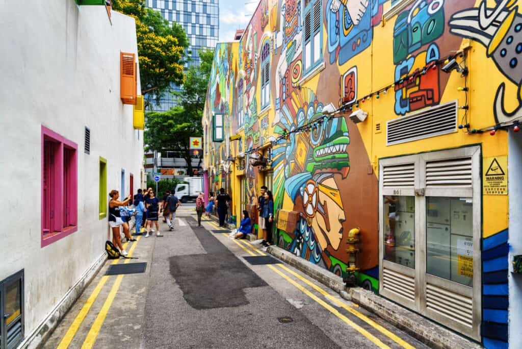 Tourists taking a picture of colorful decorative painted wall at the Gelam Gallery Singapore.