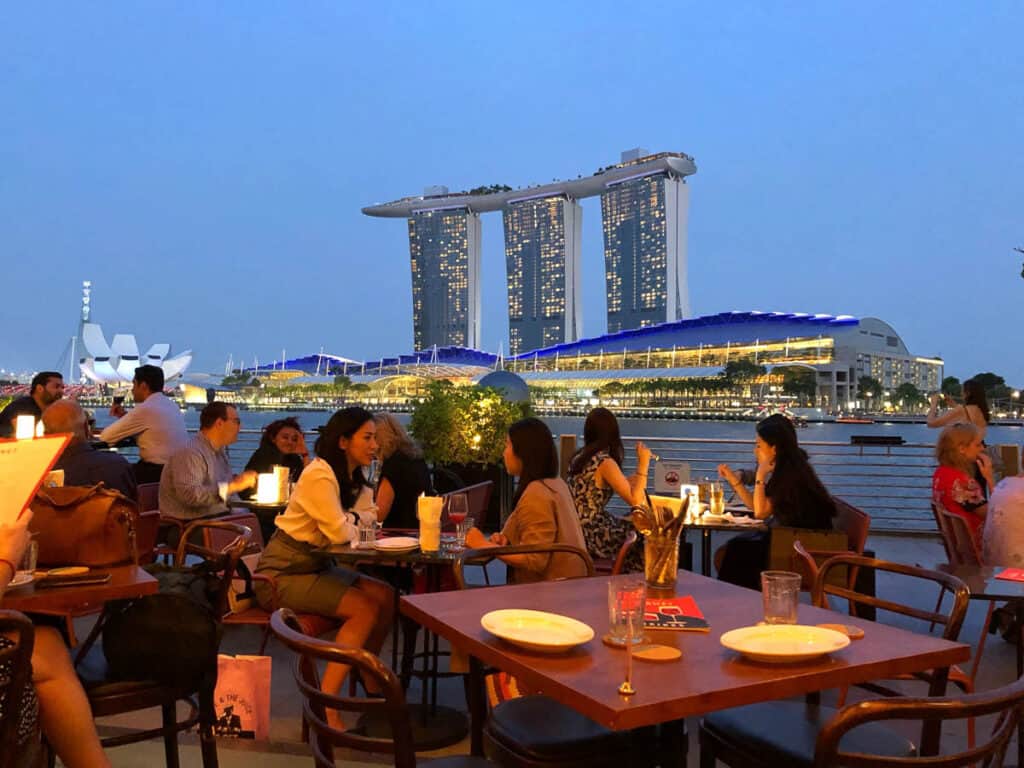 Alfresco dining in Singapore in the evening with Marina Bay Sands in background. 