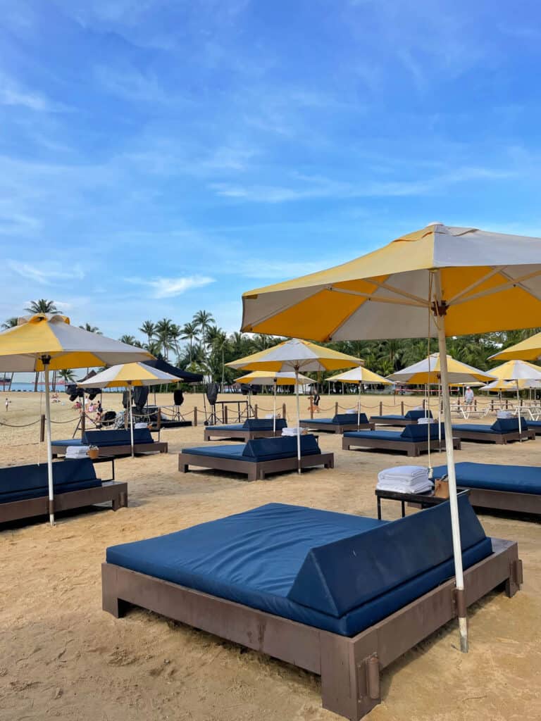 Loungers on beach at Tanjong Beach Club Sentosa. 