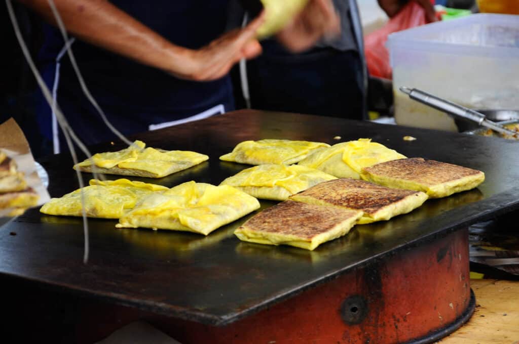 Murtabak being cooked on a hot griddle. 