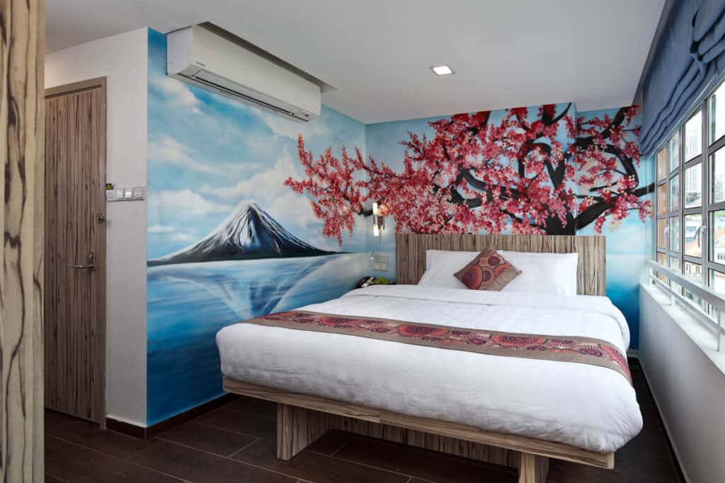 Hotel Clover the Arts room with wall mural showing cherry blossom and volcano.