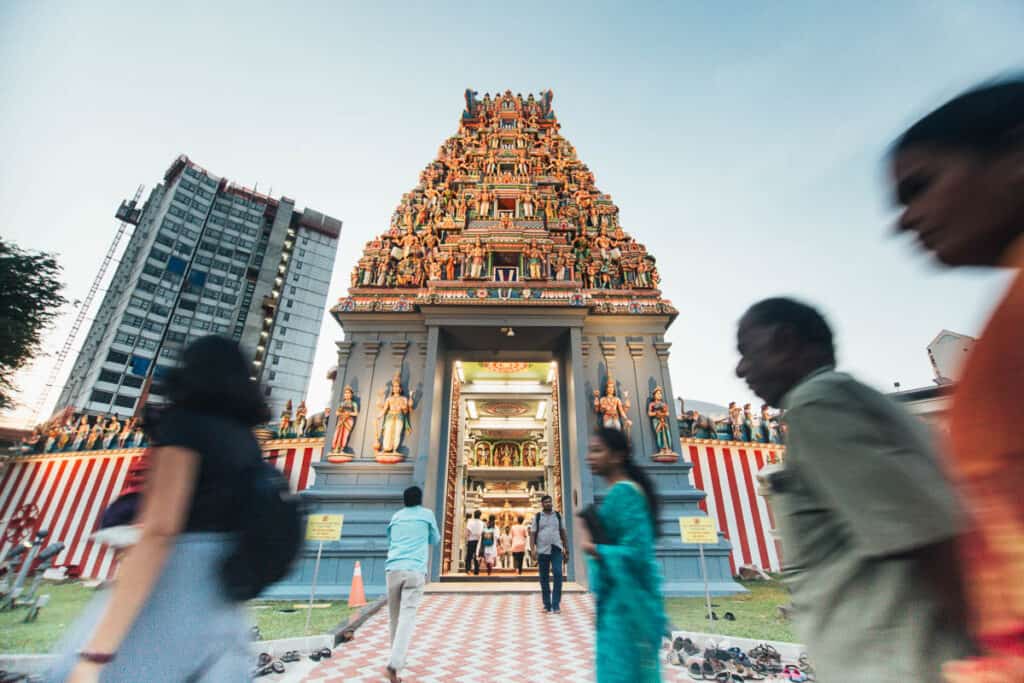 People walk past a hindu temple in Little India Singapore.