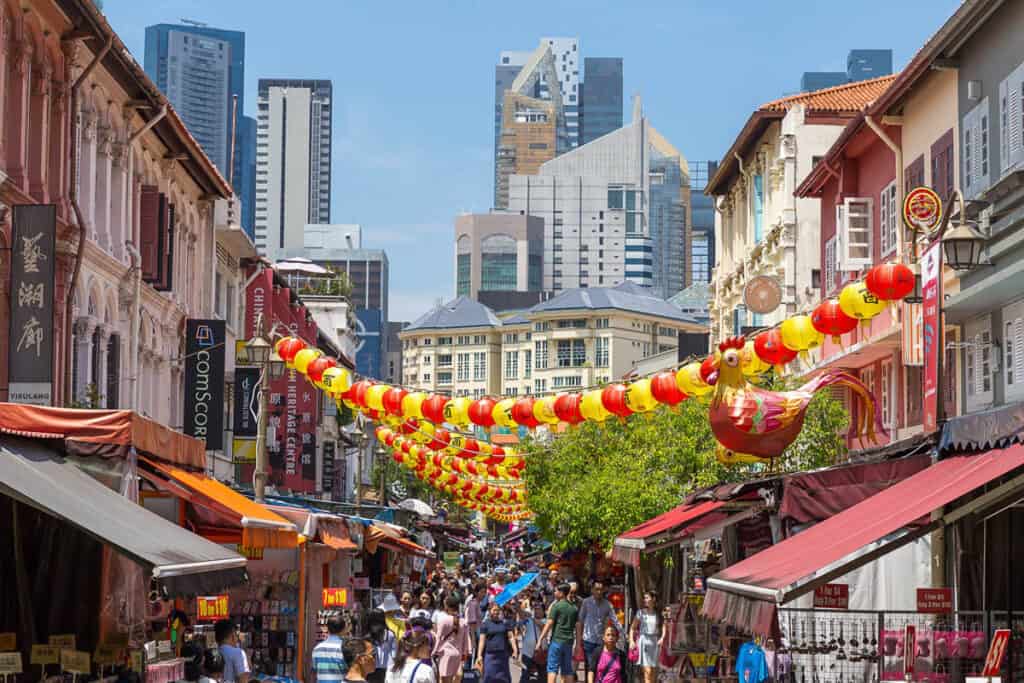 Bustling street in Singapore Chinatown with lanterns overhead. 