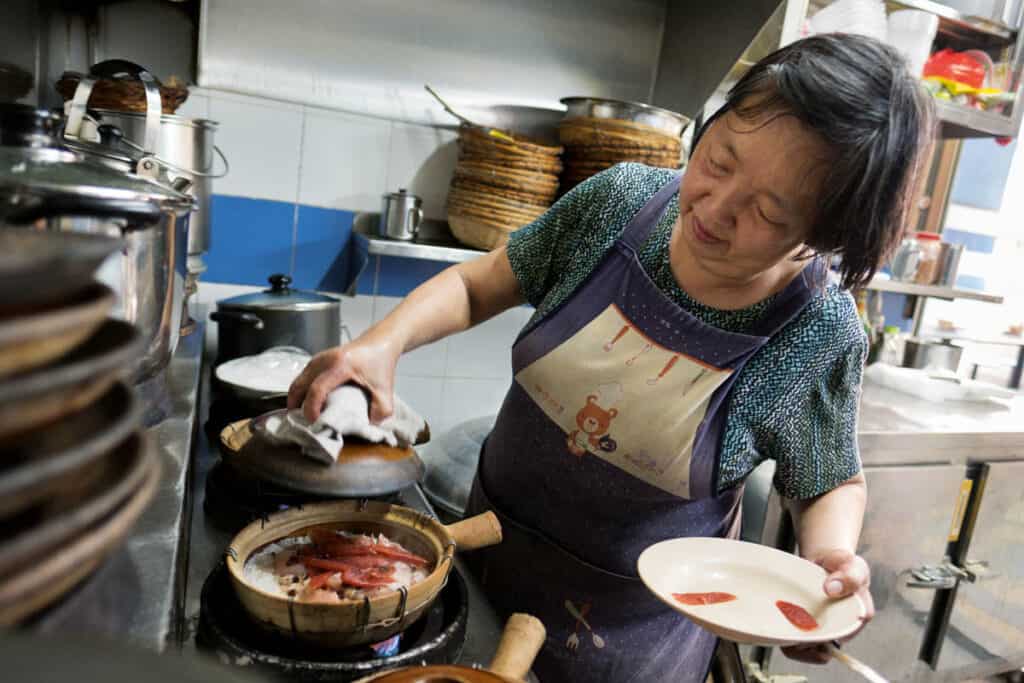 Lady making claypot at Chinatown Complex food centre. 