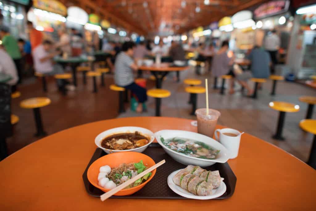 Local food dishes on a table in a hawker centre. 