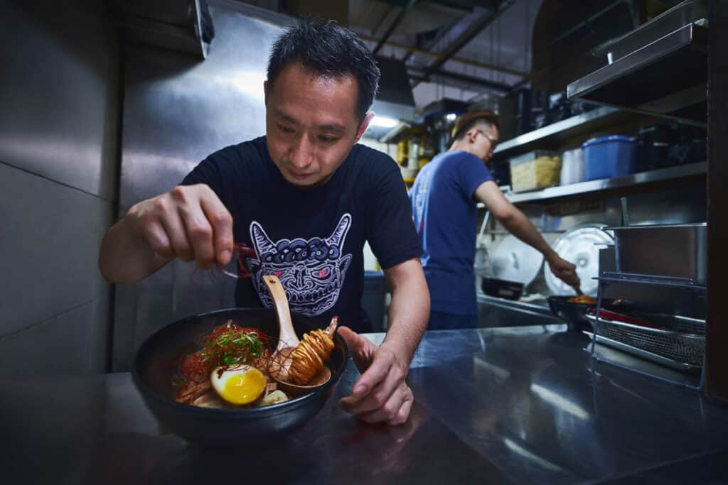 Hawker stall owners making noodle dish. 