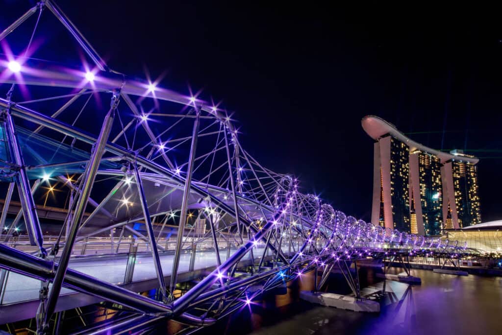 Helix Bridge lit up at night in purple lights. 