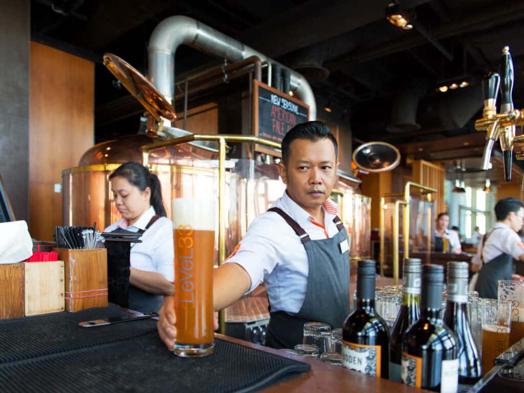 Barman serving beer at Level33 Microbrewery.