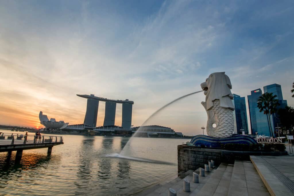 Marina Bay at sunset with Merlion in foreground. 