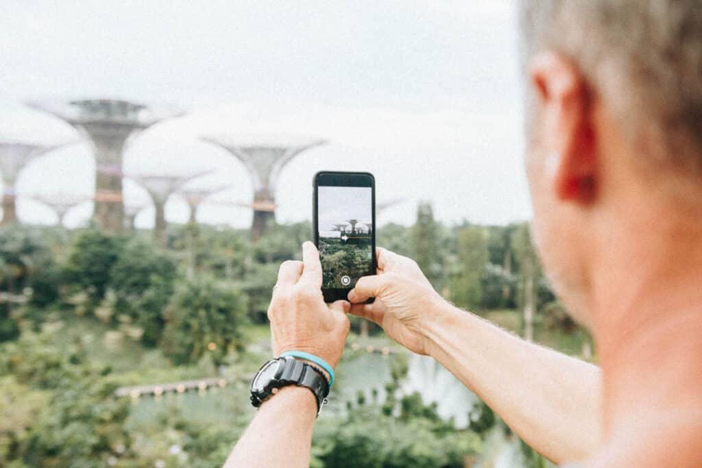 Man taking photo on phone of Gardens by the Bay Singapore.