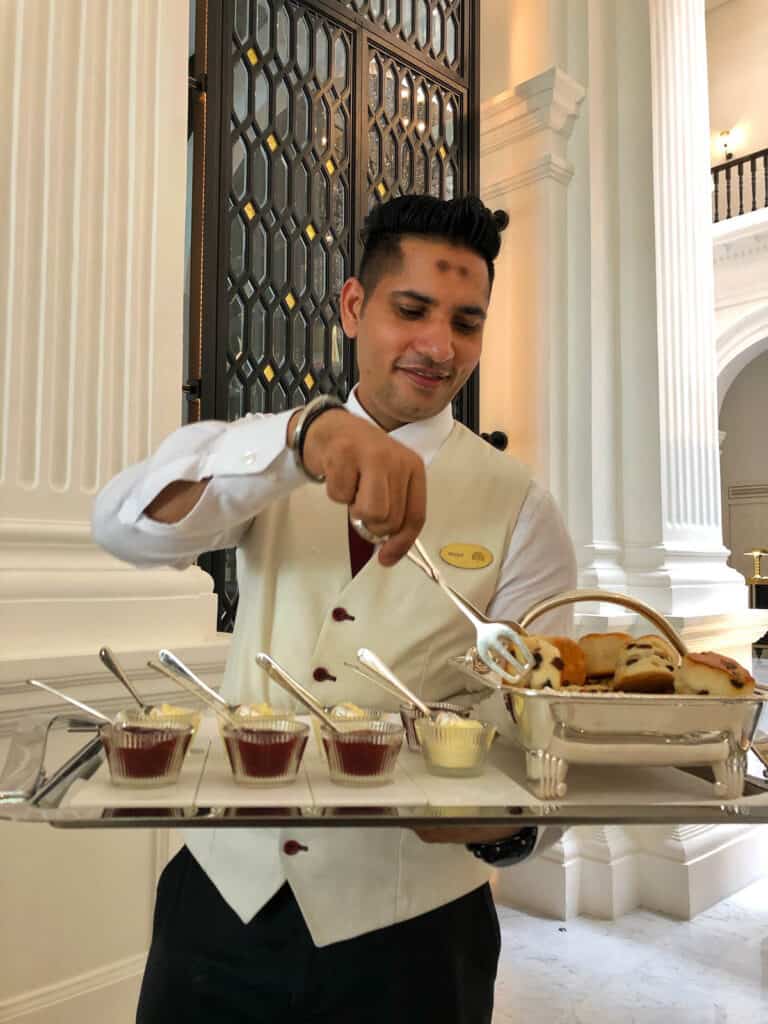 Waiter serving scones at Raffles High Tea. 