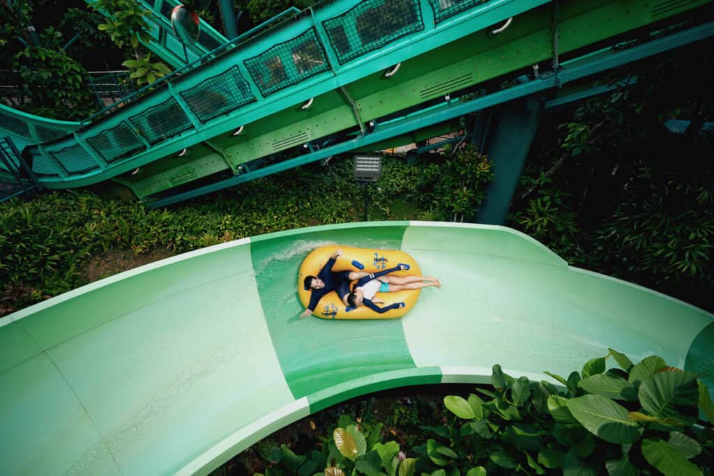 Couple on waterslide at water park on Sentosa. 