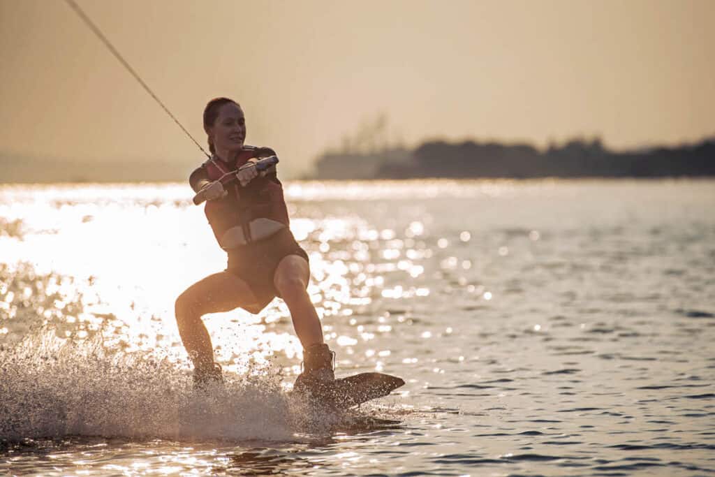 Woman wakeboarding at sunset. 