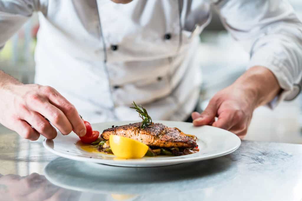 Chef preparing a plate of food. 