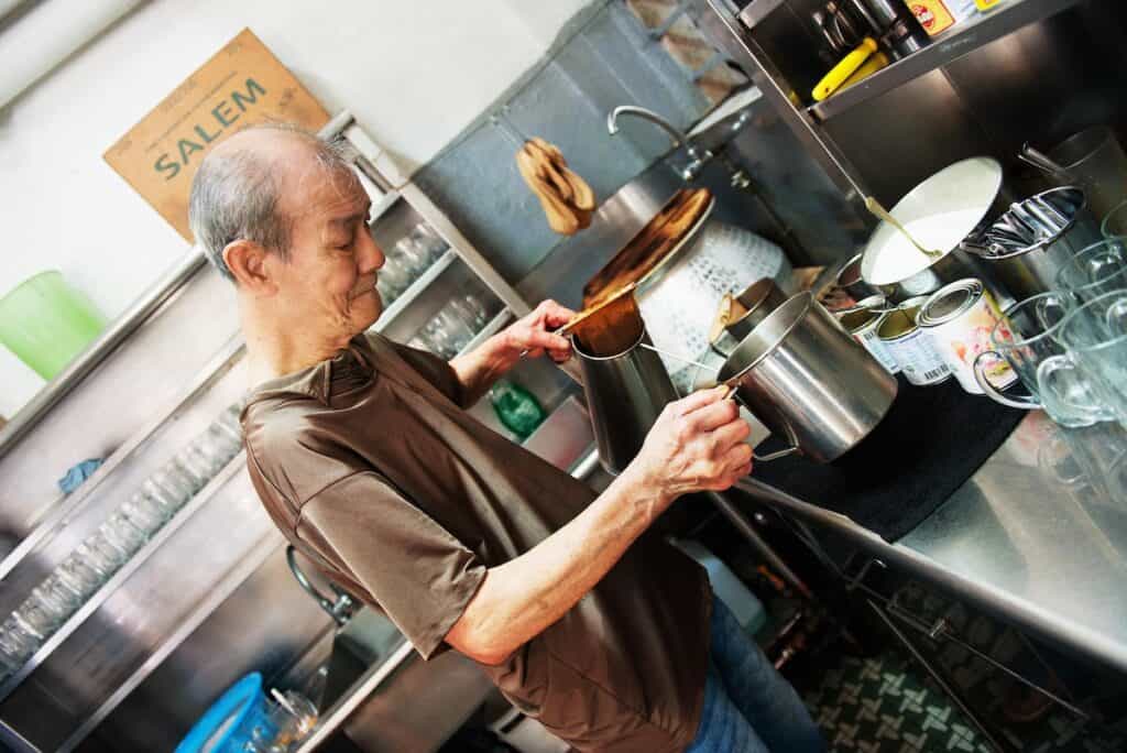 Man pouring Singapore coffee.