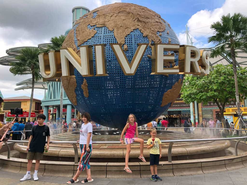 Kids with Universal Studios sign on Sentosa Island, Singapore.