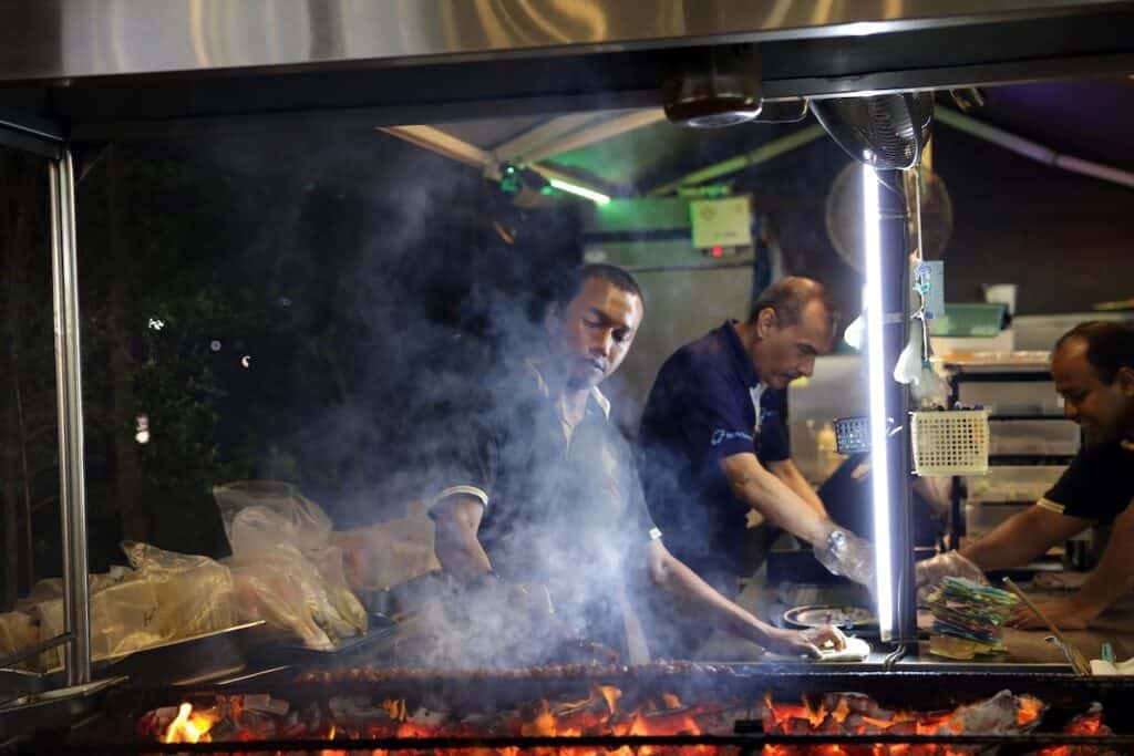 Men cooking at Satay by the Bay Singapore.
