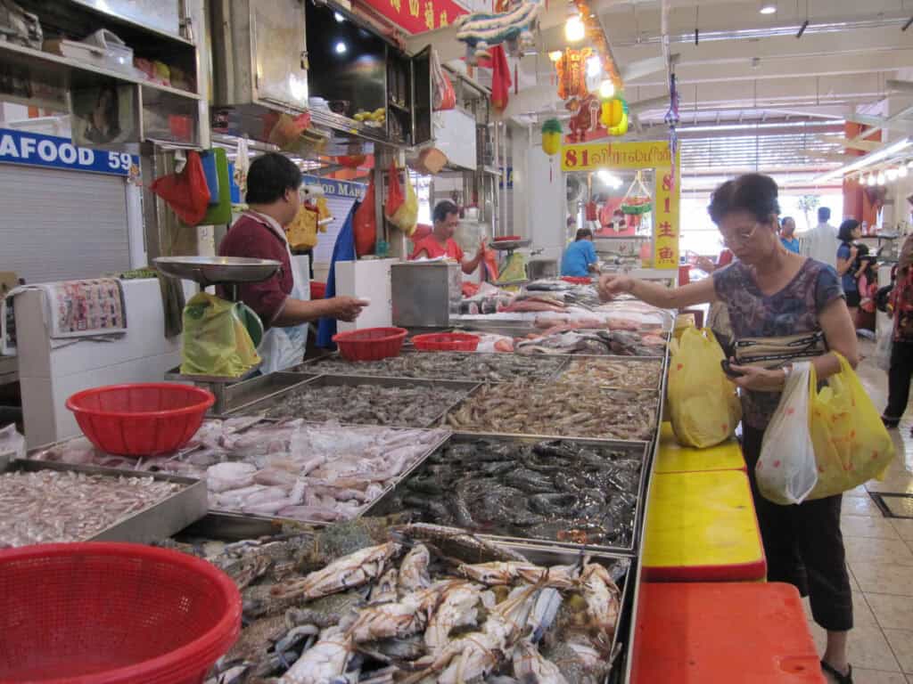 Woman shopping at a seafood stall in Tekka Centre wet market.